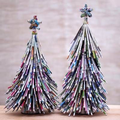 two small christmas trees made out of newspapers