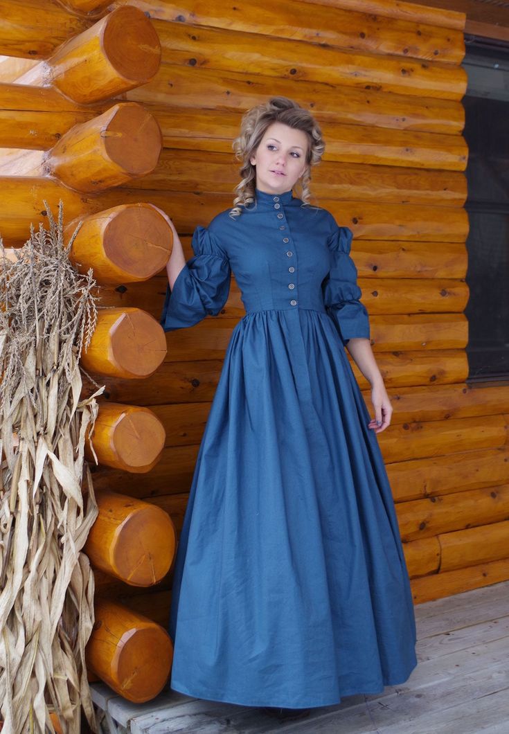 Civil War Era styled cotton dress has dropped shoulder, fitted bodice, full skirt, and double puffed sleeves with flounce. The bodice front is shaped by four darts and the closure is in the front with metal buttons. There is a short collar. The back bodice has a center back piece and 2 side back panels. The full skirt is gathered to the waistline. Hand or machine wash, tumble or air dry. Designed and made proudly in America by Recollections. Alicia is wearing boots, ruffled hoop, and jewelry and Little Women Costumes, Pioneer Clothing, Christmas Borders, Pioneer Dress, Silk Loungewear, Victorian Elegance, Farm Dress, Bustle Dress, Old Fashion Dresses