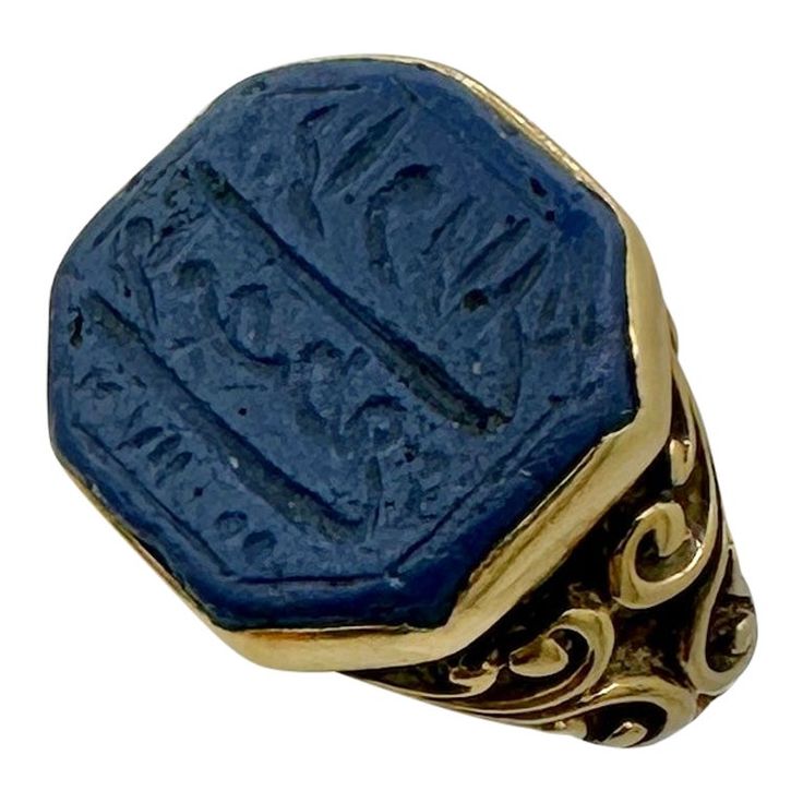 This is a stunning early antique Egyptian Revival Ring with Lapis Lazuli engraved with Arabic or Heiroglyphics in 18 Karat Gold. The fabulous ring has a wonderful blue octagonal lapis center with elegant engraving which I believe is arabic writing. The lapis is set in a cut down collet. The ring shank is a fabulous scroll open work design in 18 Karat Gold. It is very rare to find the early antique Egyptian Revival jewels, and the combination with the engraved lapis with the stunning gold work is extraordinary. For centuries, Ancient Egypt has held the fascination of the public and continues to inspire artists and designers alike. With the discoveries of Egyptian tombs, and the treasures within, in the middle of the 19th century and early 20th centuries, the exotically opulent lives of the Egyptian Revival Jewelry, Arabic Writing, Ring Shank, Egyptian Revival, Work Design, Gold Work, Ancient Egypt, Cocktail Rings, Artifacts