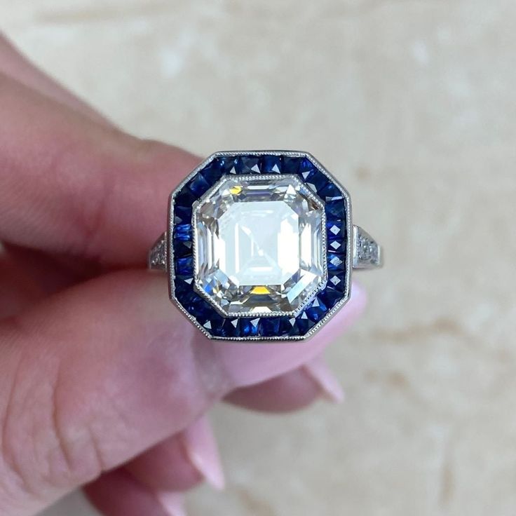 a woman's hand holding an old - fashioned diamond and sapphire ring