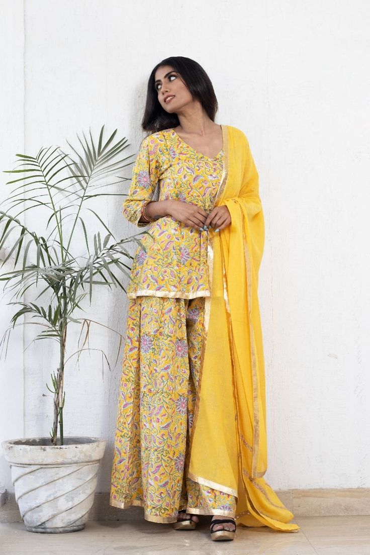 This mul-mul hand block print sharara set is a comfort wear this summer embellished with gota work and mul dupatta. Festival Cotton Silk Sharara With Printed Motifs, Festival Sharara With Printed Motifs In Cotton Silk, Yellow Chanderi Sharara With Printed Motifs, Festive Cotton Silk Sharara With Printed Motifs, Chanderi Sharara With Printed Motifs For Festivals, Festive Mulmul Sharara With Printed Motifs, Wedding Mulmul Sharara With Printed Motifs, Bollywood Style Printed Sets For Summer, Wedding Sharara With Printed Motifs In Mulmul