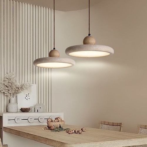 three lights hanging from the ceiling above a kitchen table with chairs and a stove in front of it