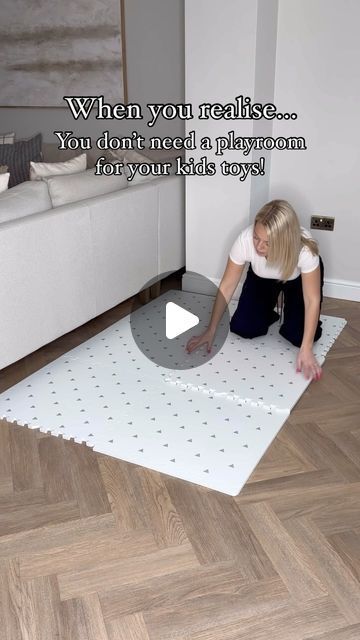 a woman kneeling down on top of a white floor next to a rug with holes in it