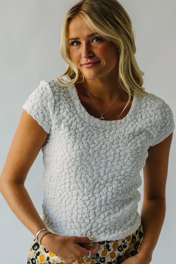 Introducing the Lervick Textured Blouse - a playful and trendy addition to your wardrobe. Its textured fabric adds a unique touch while its crisp white color pairs perfectly with any outfit. Elevate your style with this quirky, must-have piece! Details self/lining: 95% polyester + 5% spandex Fabric Care Guide Here Sizing & Fit Measurements are approximate and taken while laying flat across the front. Not doubled. x-small: bust = 16"; length = 19" small: bust = 17"; length = 20" medium: bust = 18 White Textured Tops For Spring, White Textured Top For Spring, White Textured Spring Top, White Textured Cotton Tops, Casual White Top With Soft Texture, White Textured Knit Top With Short Sleeves, Casual White Textured Tops, Chic White Textured Knit Top, White Fitted Blouse With Crew Neck