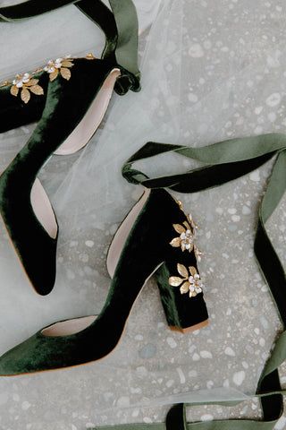 two pairs of green high heeled shoes with flowers on them