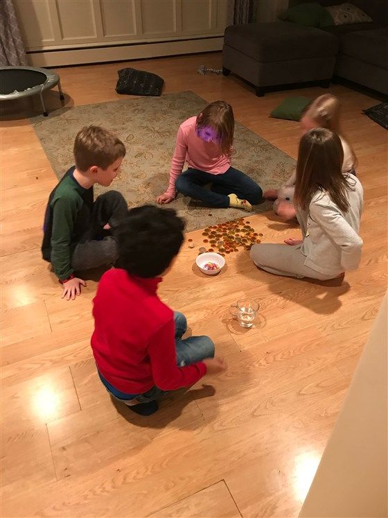 three children are sitting on the floor playing with their food and drink cups in front of them