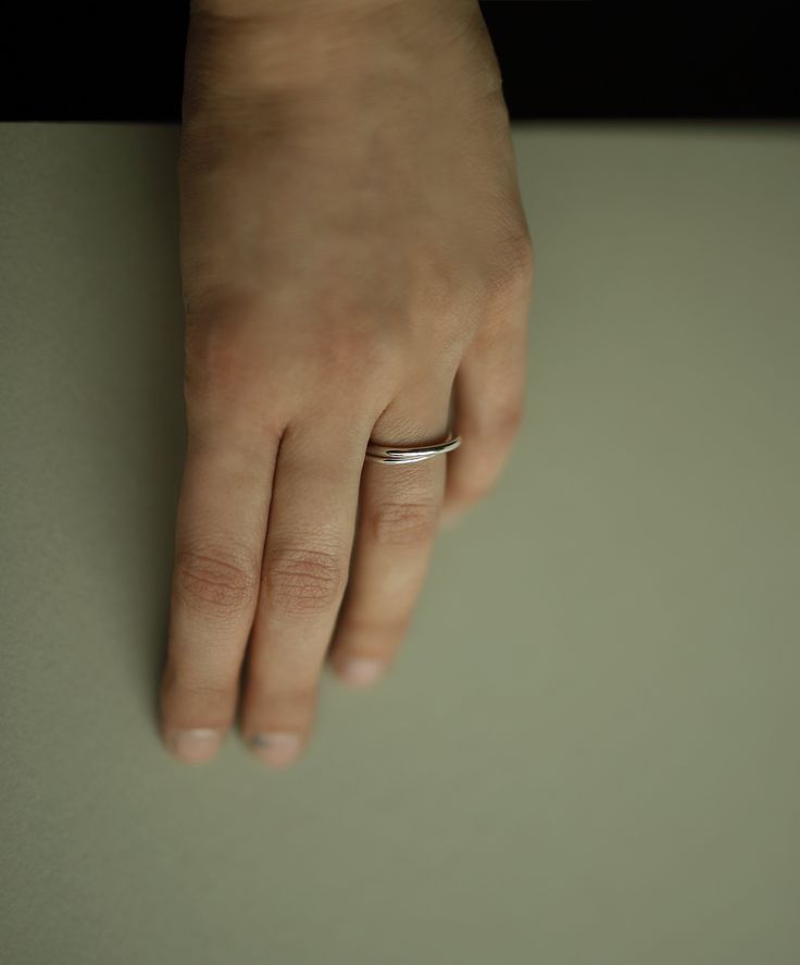 Two inseparable interlocking bands, one slender and the other with a bit of extra weight. Handcrafted in solid sterling silver with a polished finish. A distinct and timeless piece from our most recent series of rings signifying closeness. This ring looks beautiful on its own, but it can be layered with other silver and gold pieces as well. Thinner band: 1.5mm, 925 sterling silver Heavier band: 2.0mm, 925 sterling silver Shown in the fourth photo with our Gold Lovers Ring. Can't find your size? Everyday Timeless Sterling Silver Engraved Ring, Classic Silver Rings For Everyday, White Gold Rings With Thick Band For Everyday, Silver Thick Band For Everyday, Modern Bands With Ring Detail For Anniversary, Silver Signet Ring For Everyday, Silver Thick Band For Everyday Wear, Minimalist Open Band Jewelry With Shiny Finish, White Gold Engraved Ring For Everyday