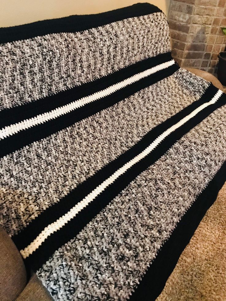 a black and white blanket sitting on top of a couch