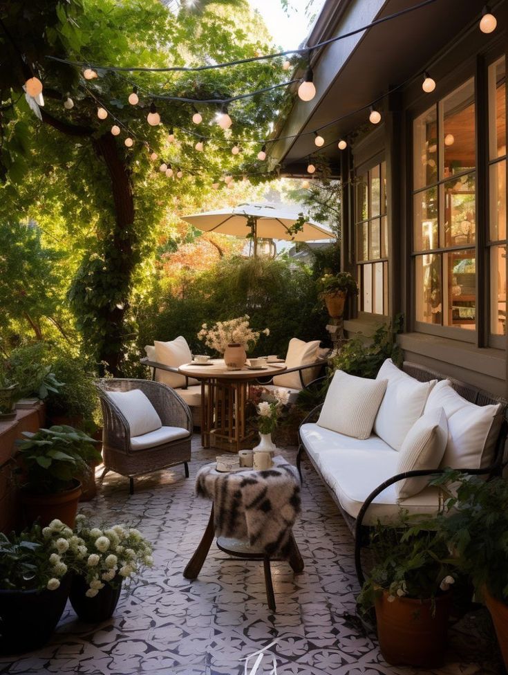 an outdoor patio with chairs, tables and potted plants on the side of it