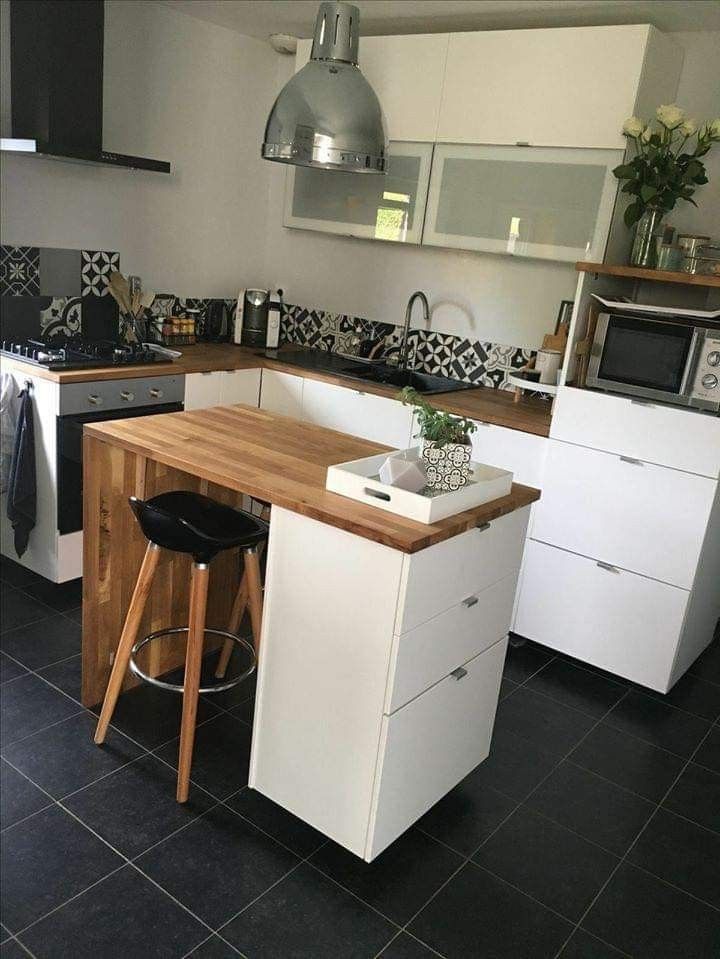 a kitchen with black and white tile flooring and wooden counter tops, two stools at the island