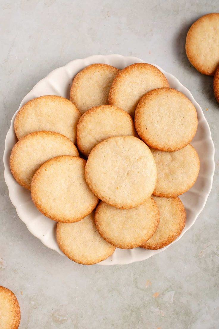 a white plate filled with cookies on top of a gray table next to other plates