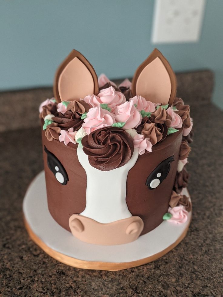 a cake decorated with flowers and a cow face