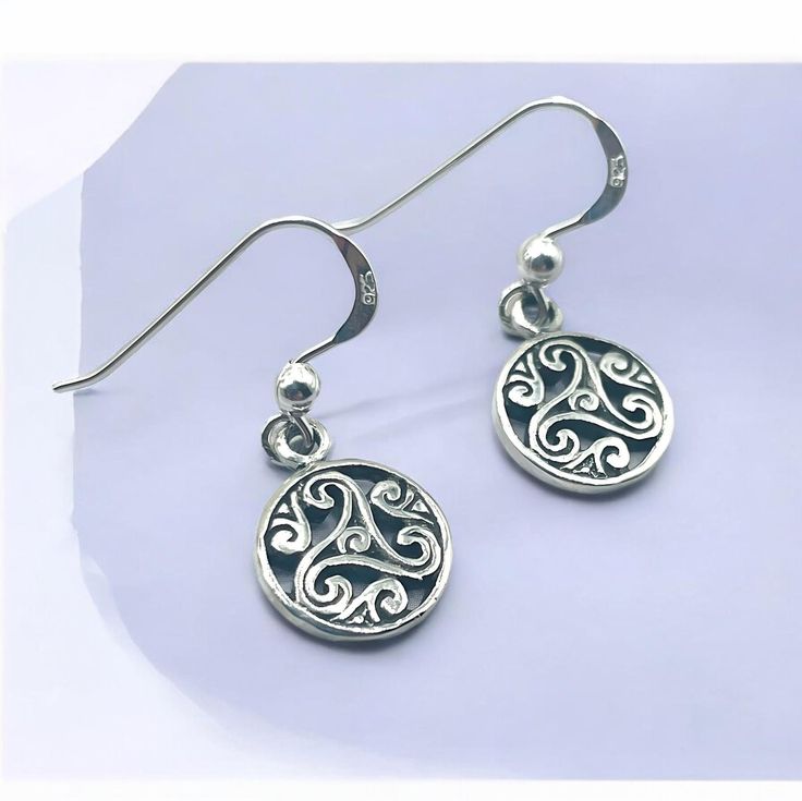 Discover the timeless elegance of our 925 Sterling Silver Triskelion Hook Earrings, an exquisite addition to any jewelry collection. Crafted with meticulous attention to detail, these earrings feature the ancient triskelion symbol, representing motion, progress, and the cycle of life. Made from high-quality 925 sterling silver, each piece is stamped with the 925 hallmark, ensuring its authenticity and superior craftsmanship. Measuring 7/16 inches in width and 1 1/32 inches in length, these earri Sterling Silver Earrings With Silver Clasp, Symbolic Sterling Silver Jewelry For Formal Occasions, Symbolic Sterling Silver Pierced Earrings, Classic Sterling Silver Earrings, Classic Hallmarked Sterling Silver Earrings, Round Engraved Sterling Silver Earrings, Engraved Sterling Silver Round Earrings, Engraved Sterling Silver Earrings, Classic Engraved Silver Earrings