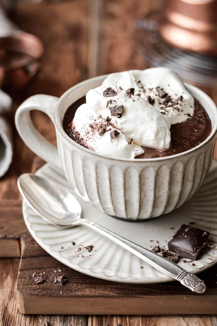 a white bowl filled with chocolate pudding and whipped cream