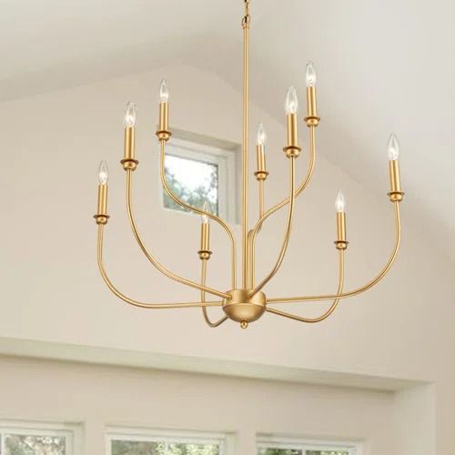 a chandelier hanging from the ceiling in a room with windows and white walls