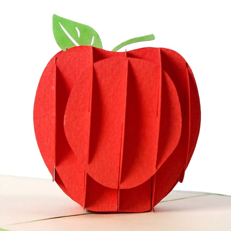 an apple made out of paper sitting on top of a table