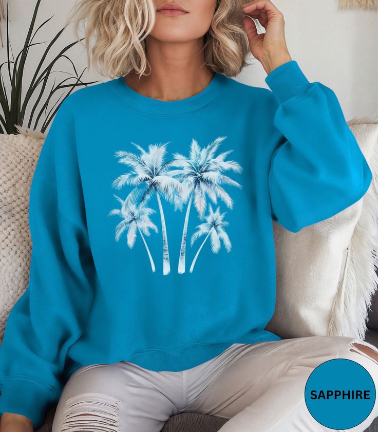 🌴Palm Tree crewneck sweatshirt!🌴 This Trendy Palm Tree sweater in a watercolor graphic is super soft and comfortable. Perfect as an oversized beach cover up or for a casual day out. Looks super cute with jeans or shorts. Makes a nice gift for Mother's Day, a Birthday or a Palm Tree lover! Comes in 9 pretty colors.🏝️ ✨PRINT: This is a handmade, Direct-to-Garment printed item. The designs are professionally printed directly on to the shirt. All over printing is used. The ink is printed directly Trendy Printed Crew Neck Sweatshirt, Cotton Crew Neck Top With Palm Tree Print, Trendy Blue Summer Sweatshirt, Trendy Blue Sweatshirt For Summer, Tropical Print Tops For Loungewear, Blue Graphic Print Summer Sweatshirt, Blue Graphic Print Sweatshirt For Summer, Long Sleeve Printed T-shirt For Vacation, Summer Crew Neck Sweatshirt With Graphic Print