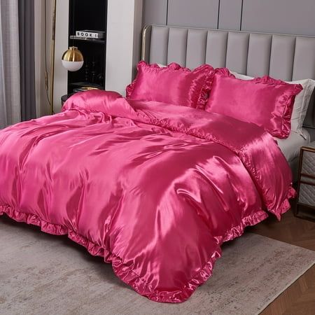 a bed with pink comforter and pillows in a room