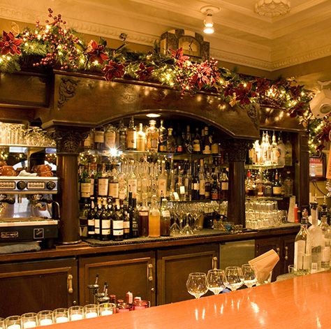 the bar is decorated for christmas with lights and candles on it, along with wine glasses