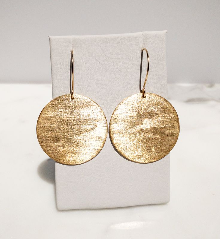 Are you looking for a unique and beautifully handcrafted accessory? Look no further than this handmade textured gold brass disc Earrings! As a single artisan handmade business based in California, I take pride in creating each pair of earrings with the utmost care and attention to detail. These earrings measure 2 inches long (including the ear wire) and 1.5 inches wide.  They are hand-textured for a unique look that makes them sparkle. They're made of solid brass.  The ear wires are also hand-made by me of 14k Gold-Fill. I believe in the quality of my work, which is why I offer a Happiness Guarantee. If for any reason you're not completely satisfied with your purchase, you can return it within 30 days for a full refund. These handmade textured gold brass circle disc earrings also make a wo Yellow Gold Circle Brass Earrings, Yellow Gold Circle Earrings In Brass, Elegant Recycled Gold Earrings With Ear Wire, Hammered Yellow Gold Circular Earrings, Yellow Gold Hammered Circle Earrings, Round Recycled Gold Earrings As Gift, Adjustable Hammered 14k Gold Earrings, Yellow Gold Round Earrings With French Hook, Brass Round Earrings With French Hook