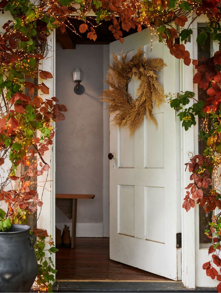 an open door with a wreath hanging on it's side next to a table