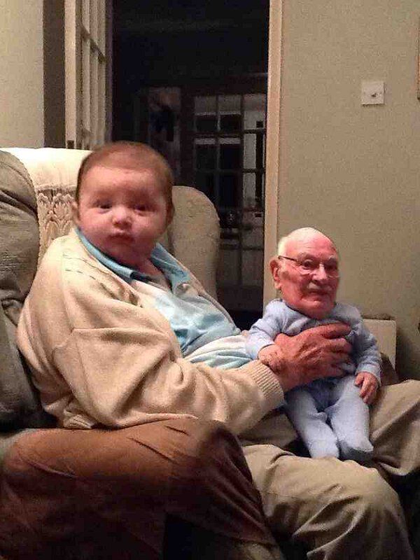 an older man holding a baby in his lap