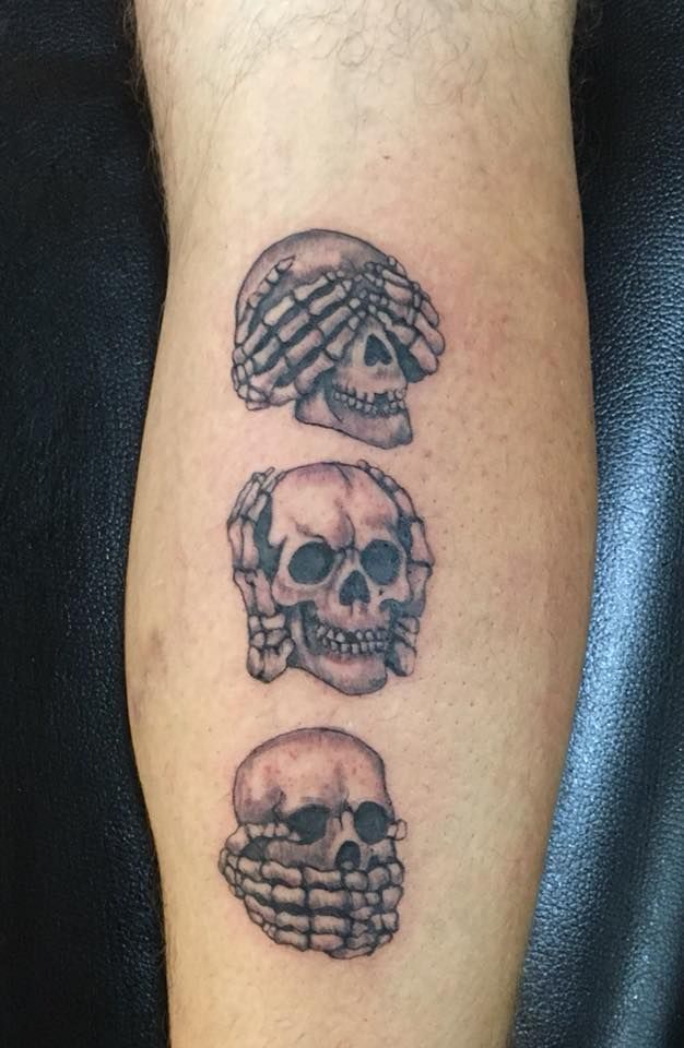 three skull tattoos on the arm