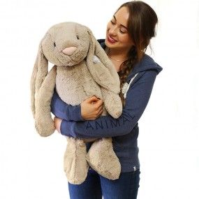 a woman holding a large stuffed rabbit in her arms