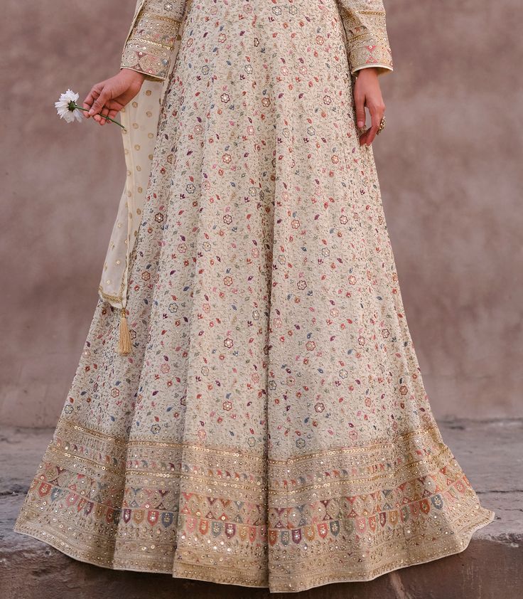 COLOR : Smokey Taupe FABRIC : Gown & Dupatta - Premium Georgette WORK : Heavy Zari Work, Resham Embroidery, Hand Work, Motifs, Stones, Swarvoski, Mirrors, Sequins, Embellished Lace Border OCCASION : Wedding, Reception, Engagement, Bridal Wear READY-TO-WEAR : NoSTITCHING : Available as semi-stitched fabric, can be stitched using standard size option (+$30). Note: There might be a slight color variation due to lighting and flash used during photoshoot. The bright shade seen is the best closer view of fabric's color. Semi-stitched Maxi Lehenga With Intricate Embroidery, Multicolor Embroidered Gown With Resham For Eid, Multicolor Embroidered Gown With Resham Embroidery For Eid, Multicolor Embroidered Gown For Eid, Maxi Length Salwar Kameez With Intricate Embroidery For Reception, Unstitched Anarkali Gown With Intricate Embroidery, Semi-stitched Anarkali Dress With Floral Embroidery, Designer Wear Anarkali Embroidered Fabric, Semi-stitched Maxi Length Dupatta With Floral Embroidery