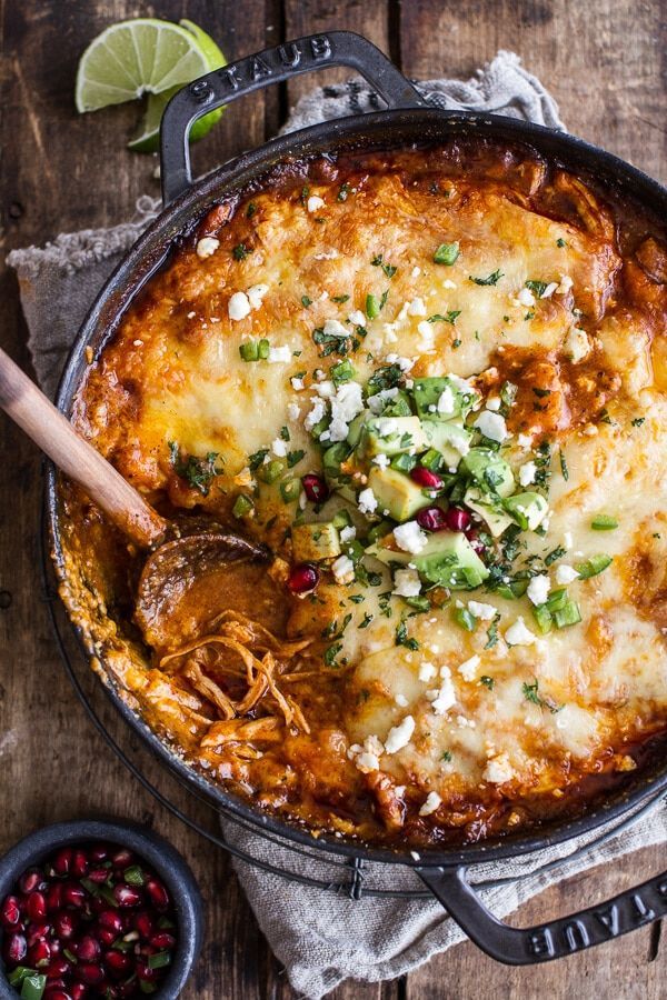 a casserole dish with cheese, meat and vegetables in it on a wooden table