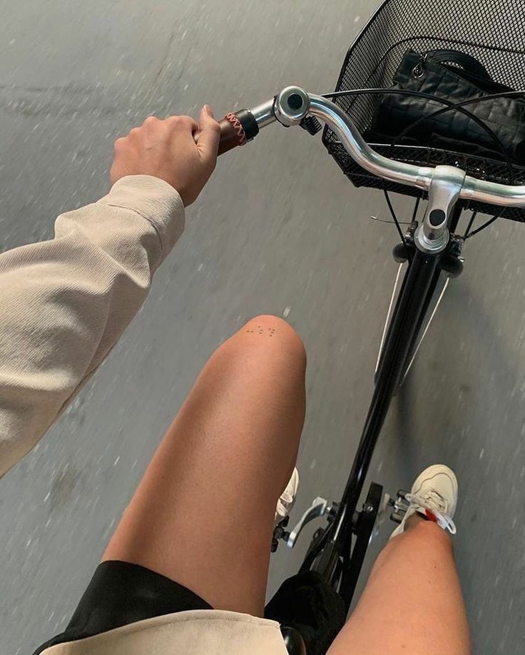 a person riding a bike in the rain with their feet on the handlebars