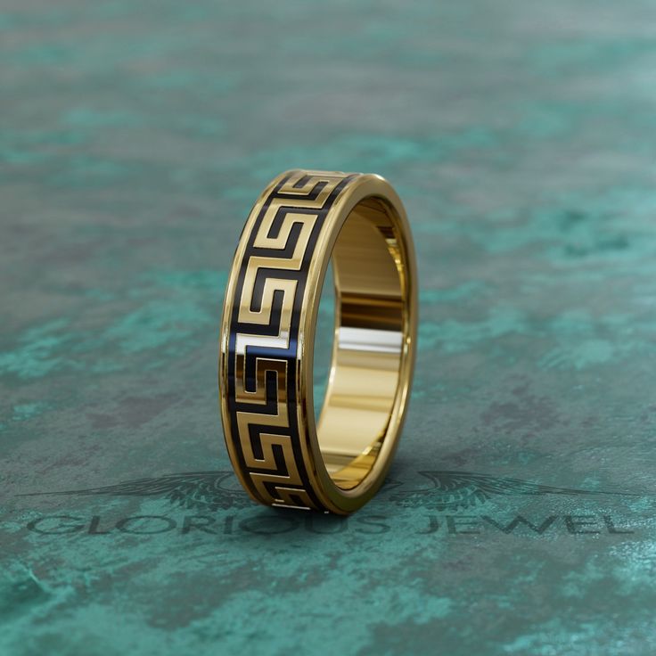 a gold wedding ring with greek designs on it