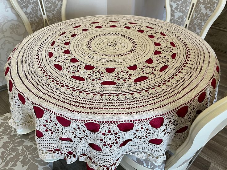 a table with a red and white doily on it sitting next to two chairs