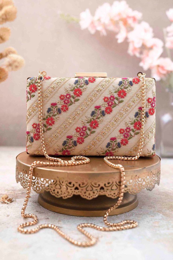 "Dropping our regal Resham clutch into the time capsule. The meticulous embroidery features beautiful gold zari and thread work, accentuated with sequins. Pick up this timeless clutch if you are someone seeking for a classic and royal accessory. It can be styled in a variety of ways to suit any occasion making it perfect for both day and evening fits. Embroidered front and back. Dimensions (LxB): 7.75\"x4.5\" Handle length: 47\" Handle drop: 23\" Material: Embroidered silk, poly satin lining, go Evening Fits, Embroidered Clutch Bag, Unique Clutch, Diy Bag Designs, Embroidered Clutch, Silk Bag, Box Clutch, Diwali Gifts, Wedding Bag