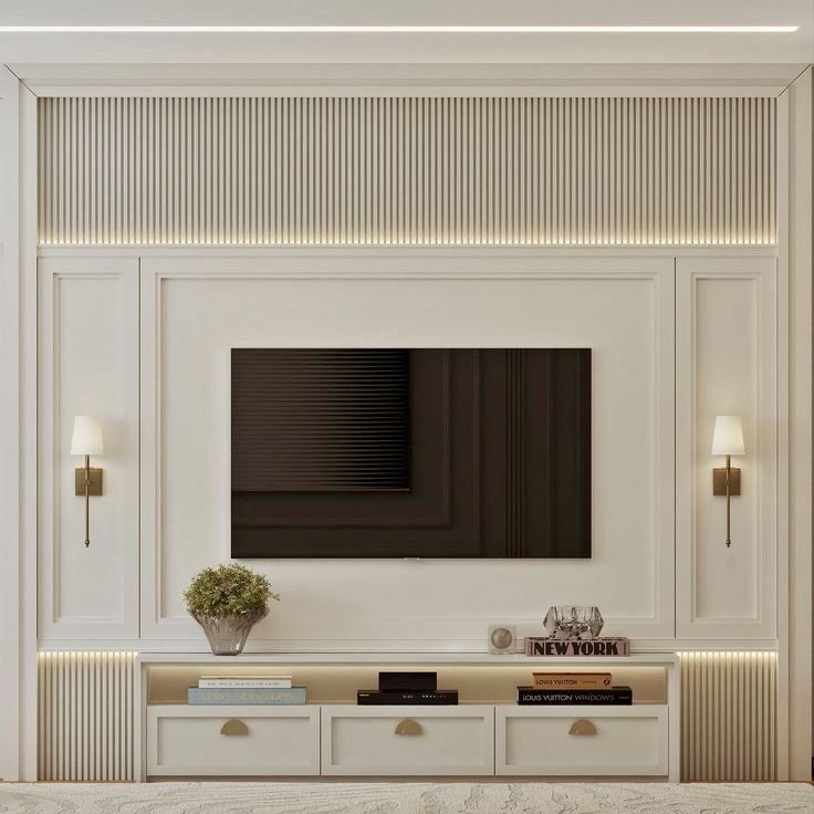 a living room with white furniture and a flat screen tv mounted on the wall above it