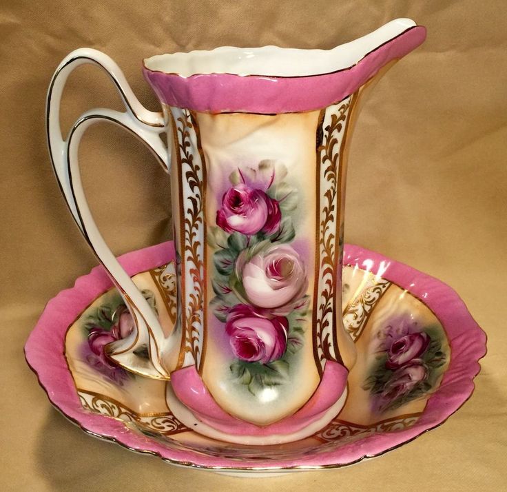 a pink and white vase sitting on top of a saucer with matching plates around it