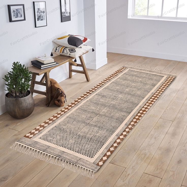 a large rug on the floor in a room with wooden floors and pictures hanging on the wall