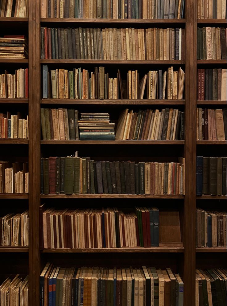 a bookshelf filled with lots of books on top of wooden shelves