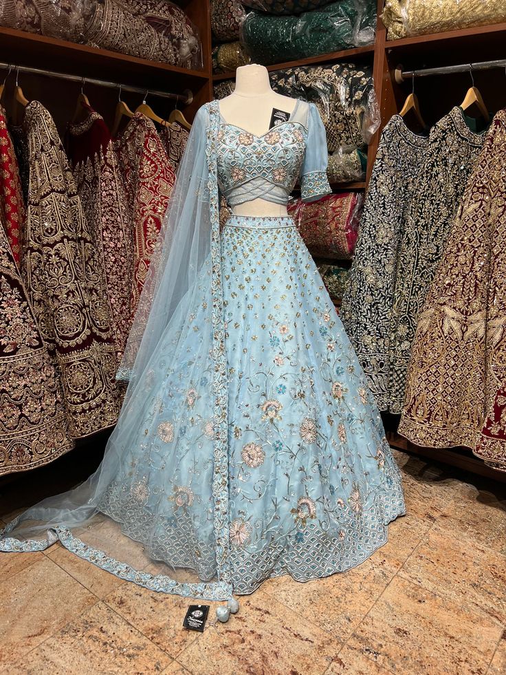 a blue lehenga is on display in a store with other clothes and fabrics