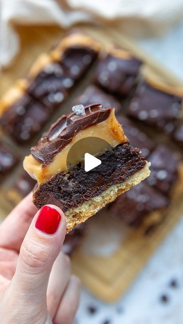 a person holding up a piece of chocolate cake