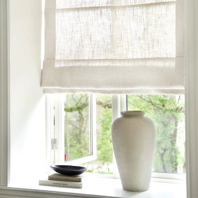 a white vase sitting on top of a window sill