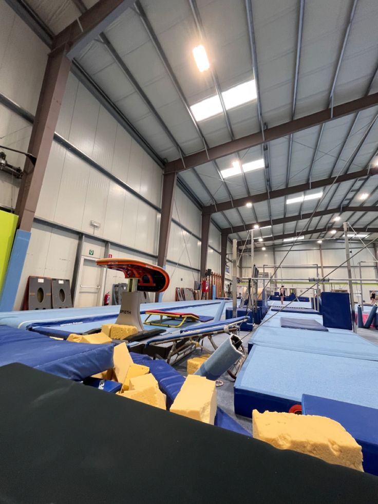 an indoor trampoline facility with blue tarps and yellow foam on the floor