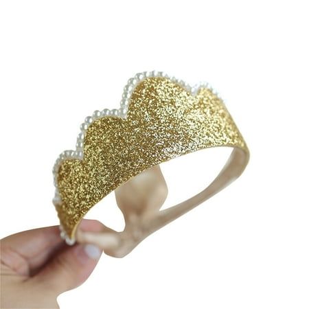 a hand is holding a gold and white tiara