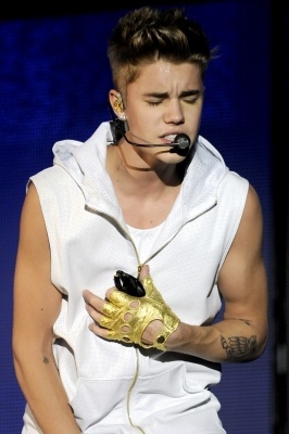 a man wearing a mask and holding a cell phone in his hand while standing on stage