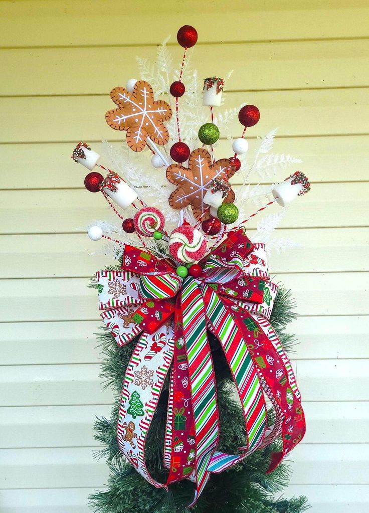 a christmas tree decorated with candy canes and decorations on top of it's base