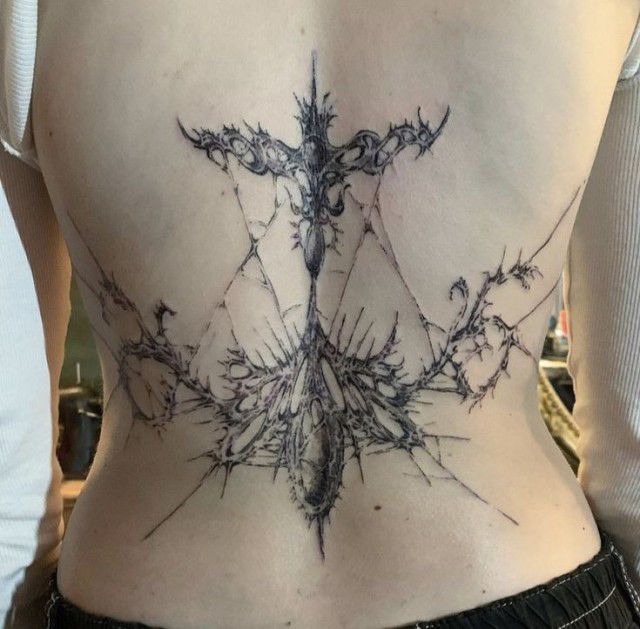 the back of a woman's stomach with an intricate design on her lower back