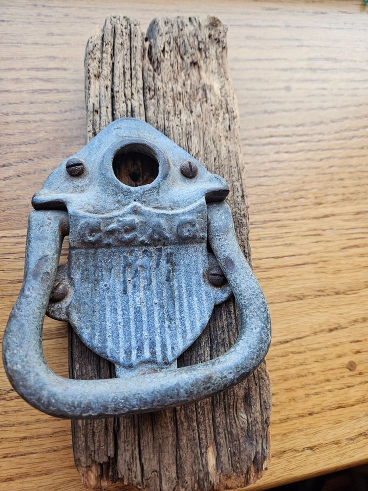 an old cast iron door handle on a wooden post