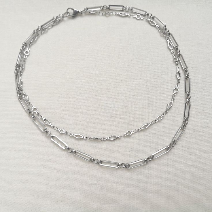 "A minimal stainless steel layered necklace. This chunky chain necklace is made from two lengths of stainless steel chain (the colour is not bright, unlike silver equivalents). This necklace is perfect as a gift for someone special in your life or treating yourself. Great for layering or can be worn on its own. Please note that the chains are joined together at the back and this is not a listing for two separate necklaces. Necklace length options: - 14\" and 16\" (approx. 35.5 cm and 40.5 cm) - 16\" and 18\" (approx. 40.5 cm and 45.5 cm) This necklace is made to order. Packaging: Please choose your packaging type from the drop down menu.                   - Pink card envelope (as shown in the listing photo)                    - White gift box (gift wrapped with tissue paper and a satin bow Minimalist Oval Link Chain Necklace For Layering, Minimalist Double Chain Necklace, Minimalist Double Chain Choker Necklace, Modern Jewelry With Paperclip Chain For Layering, Minimalist Double Strand Layered Necklace, Minimalist Double Chain Link Necklace, Silver Chain Link Layered Necklace, Metal Cable Chain Necklace For Layering, Trendy Everyday Metal Layered Necklace