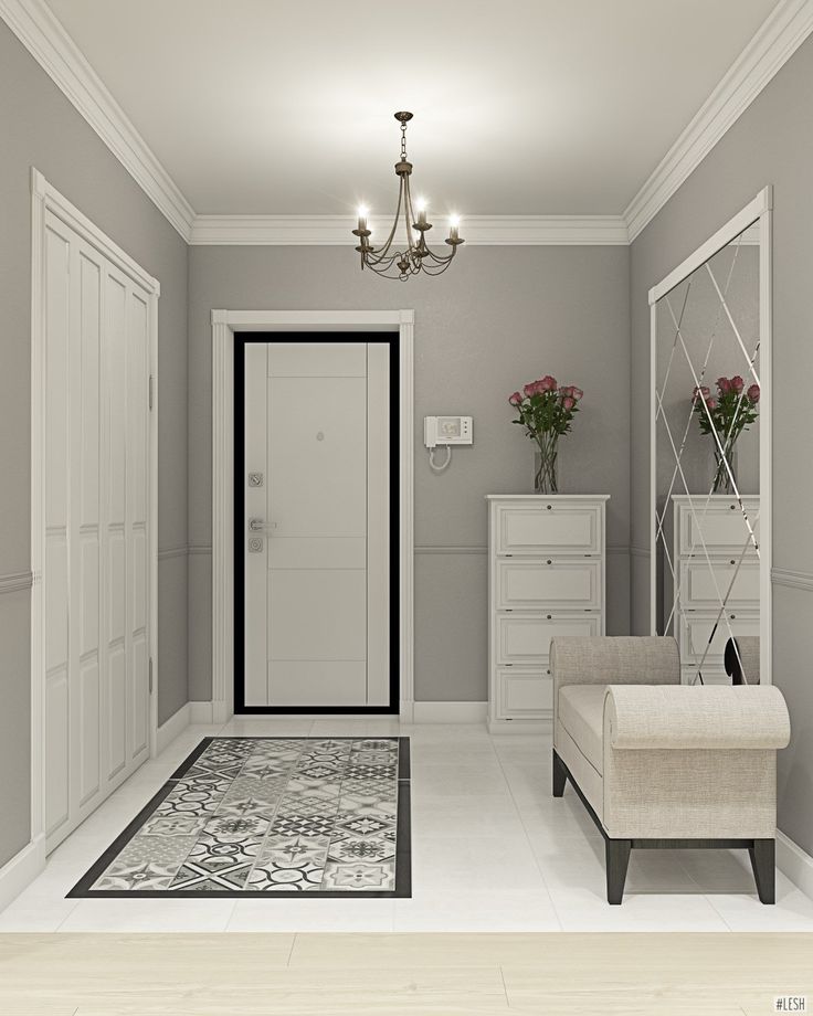 an empty room with white furniture and chandelier