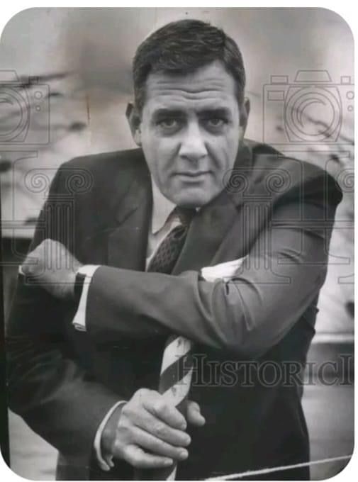 an old black and white photo of a man in a suit with his arms crossed